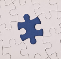 White puzzle with one piece missing on blue background